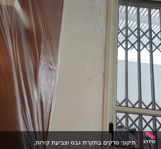 קיר גבס עם סימני רטיבות ליד חלון